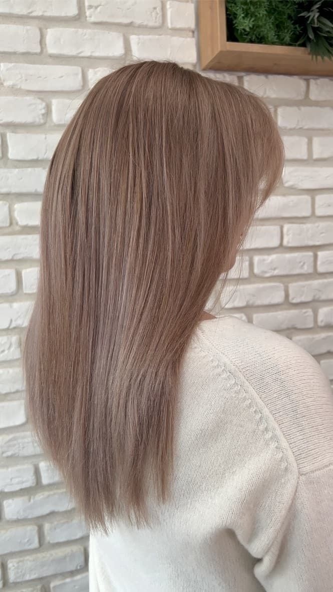 Airtouch: rovné dlouhé vlasy v béžové blond se světlejšími pramínky, na pozadí zelená stěna