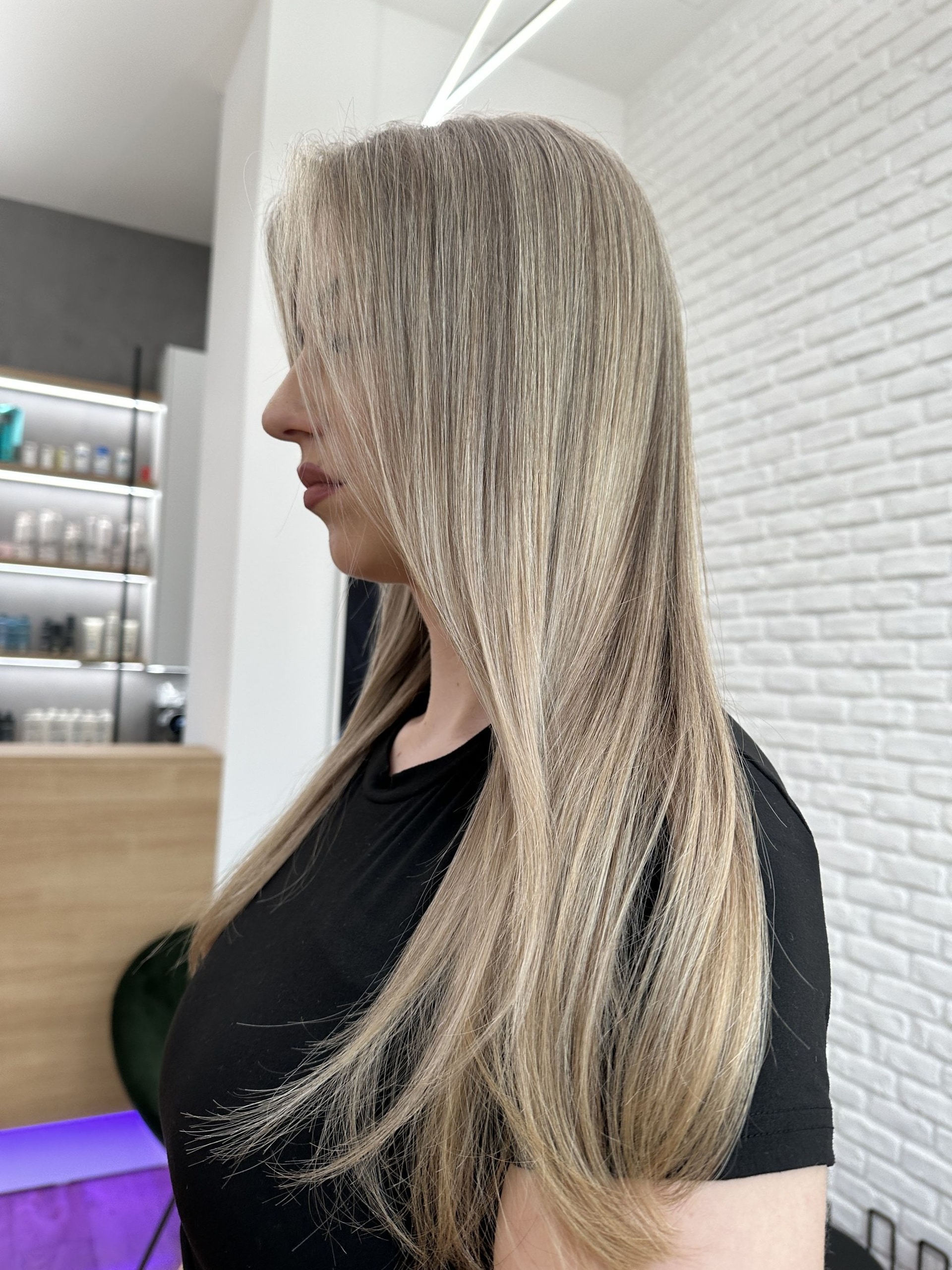 Airtouch se střihem: dlouhé rovné blond vlasy se světlejšími prameny u obličeje, v salonu (Klára Valnerová)