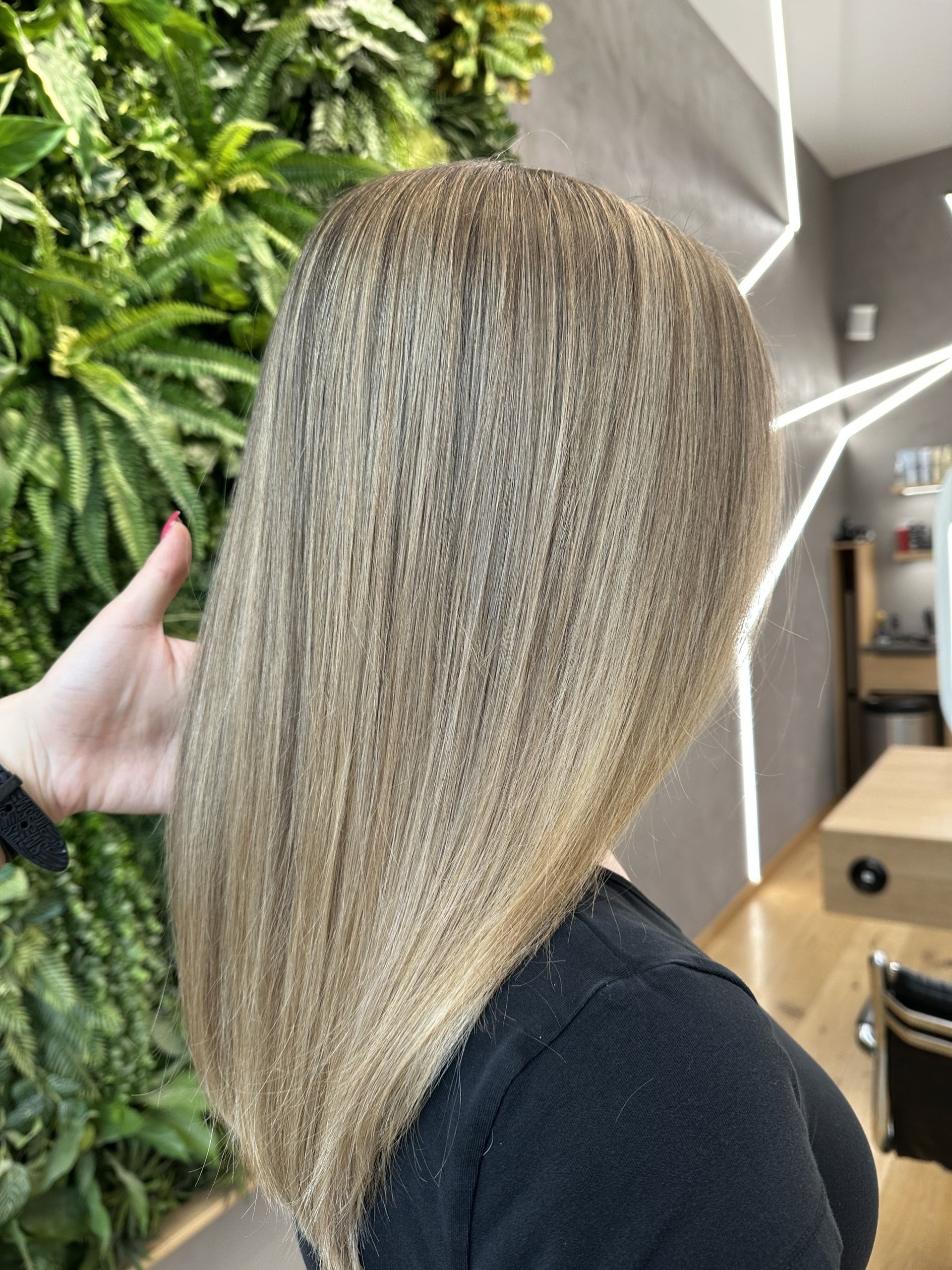 Airtouch se střihem: dlouhé rovné popelavé blond vlasy, ruka jemně držící pramen (Klára Valnerová)