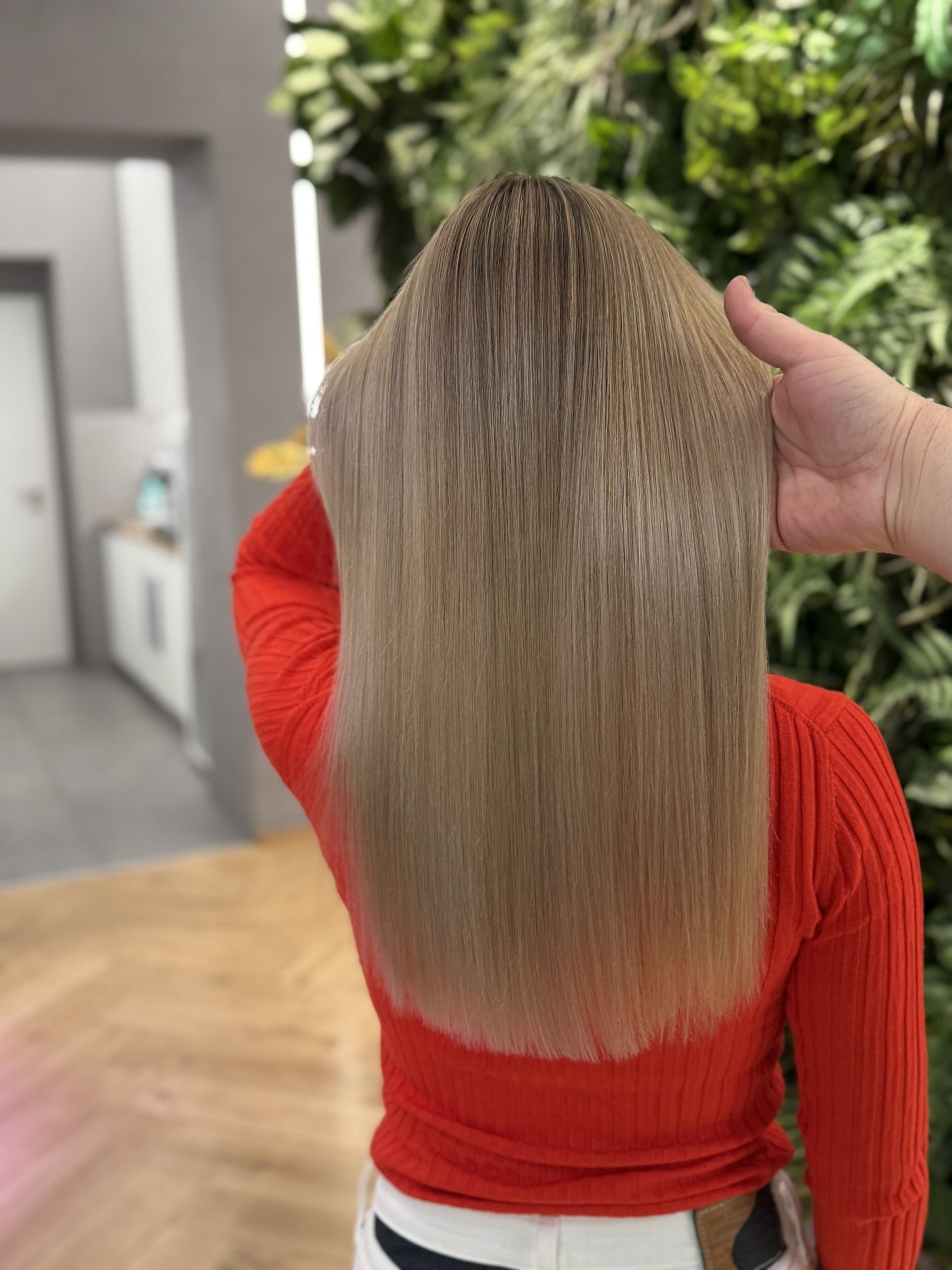 Airtouch se střihem: rovné vlasy pod ramena v pískové blond barvě, ruka drží prameny (Jaroslav Vlček)