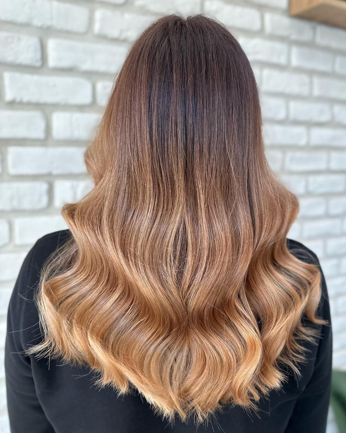 Balayage: dlouhé vlny po lopatky, tmavě hnědé kořínky a teplé měděné až zlaté délky s odlesky