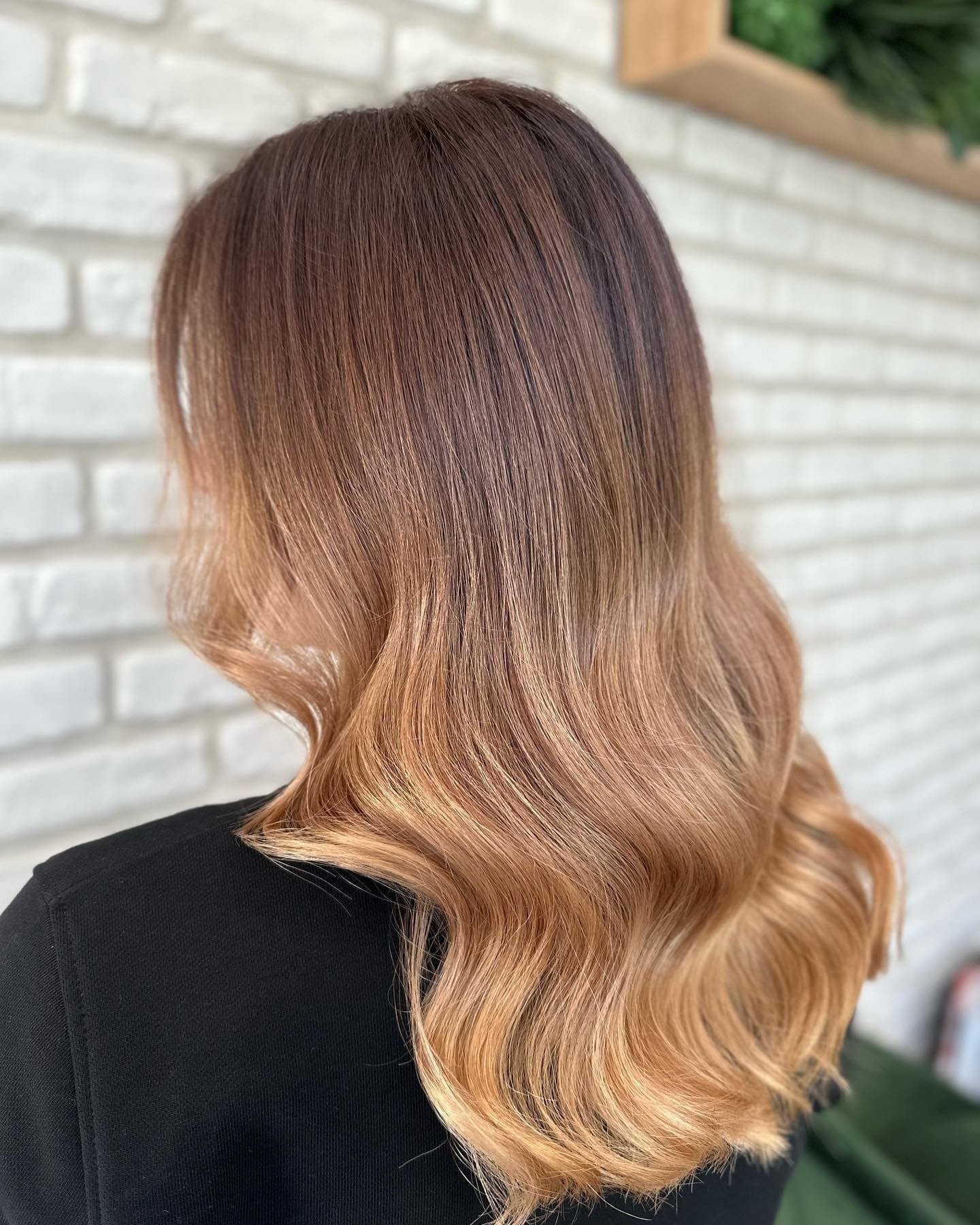Balayage: vlnité vlasy po ramena, plynulý přechod z tmavě hnědého kořínku do zlatých karamelových konců