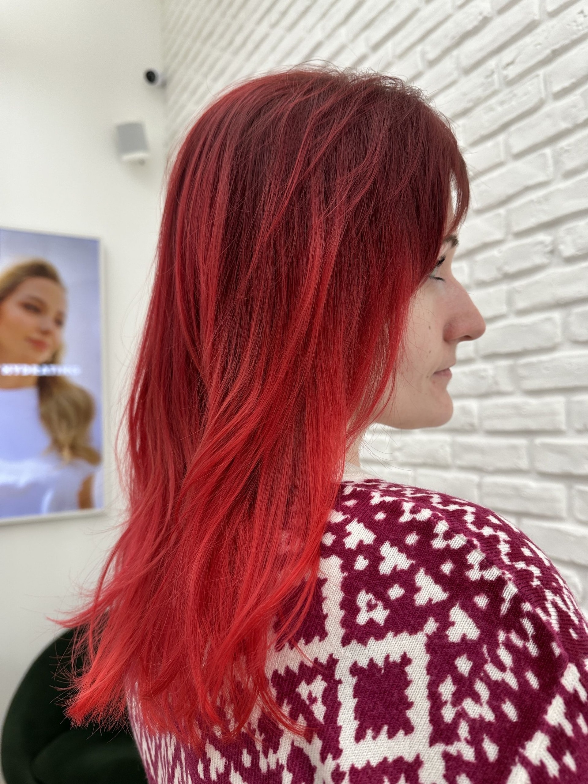 Kreativní barvení: vlasy po lopatky v červené barvě s ofinou a tmavším kořínkem, bílá cihlová zeď (Klára Valnerová)