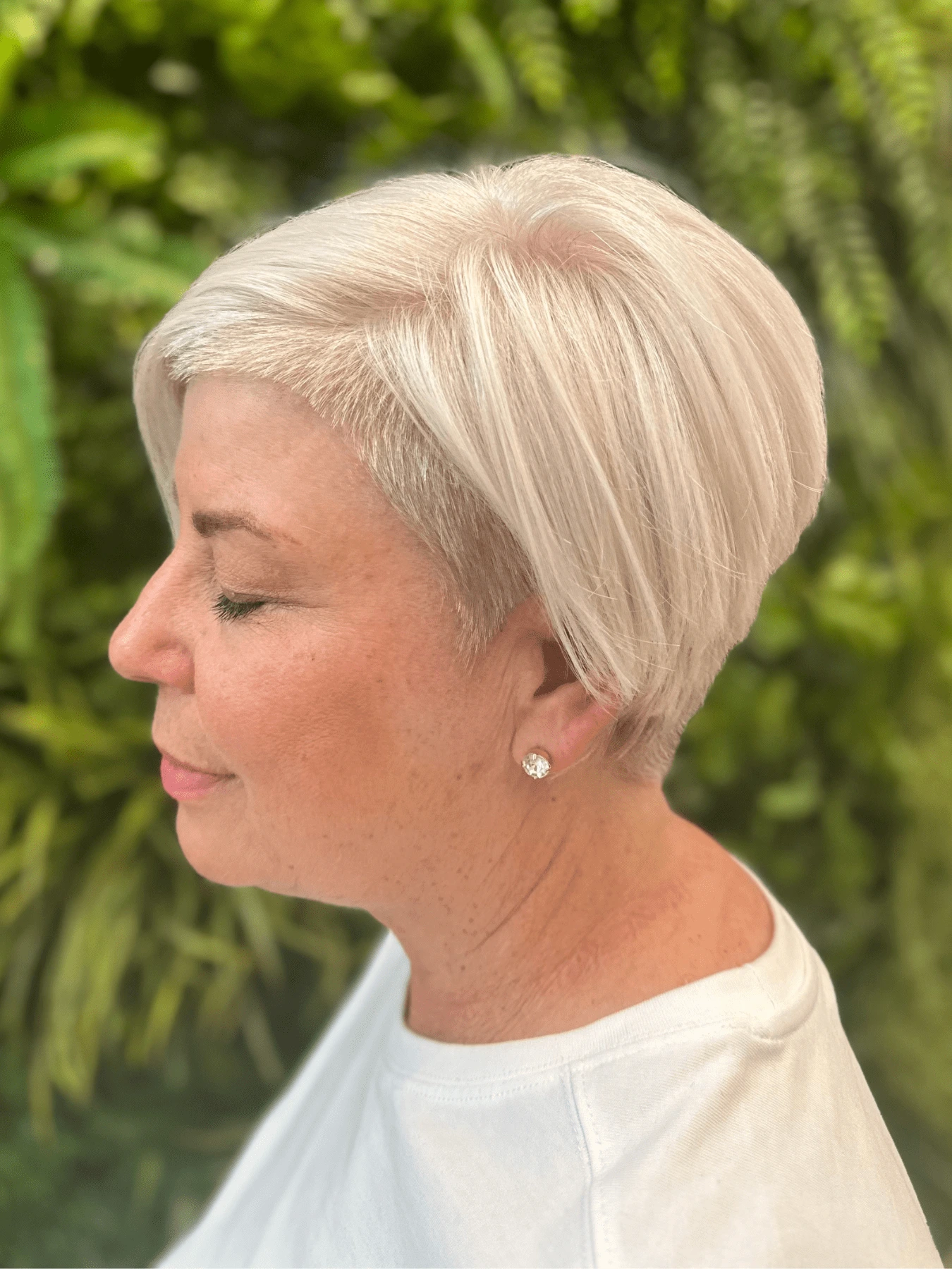 Permanentní barva celých vlasů se střihem: krátké platinově blond vlasy, delší pramen v ofině sčesaný do strany, kratší za uchem (Romana Fröhlichová)